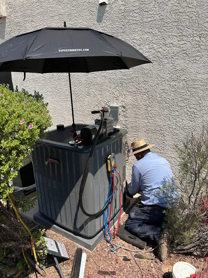 HVAC technician performing outdoor AC maintenance in Windham